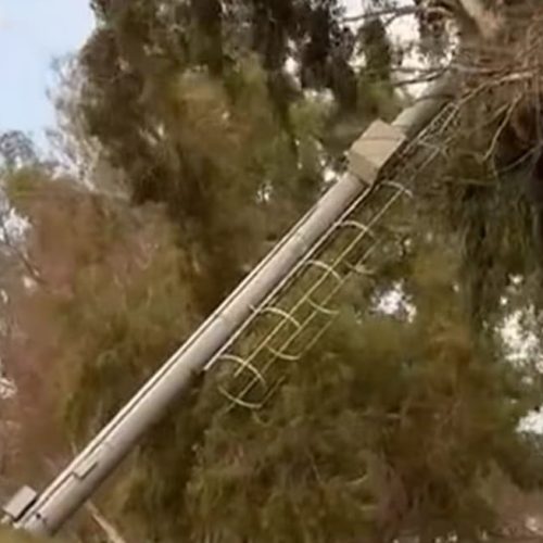 Un poste cae por el viento y queda suspendido en un árbol