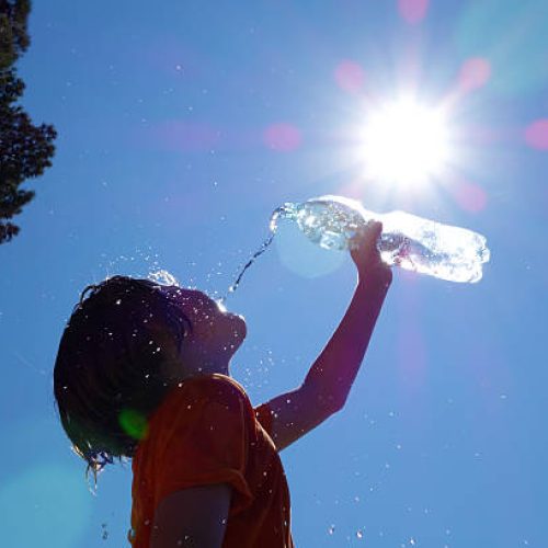 Child pouring water on himself.